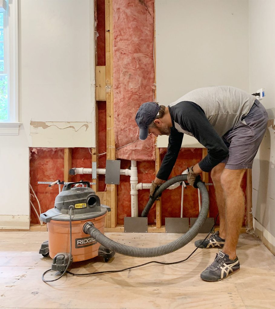 John Using Shop Vac To Remove Dust During Bathroom Renovation