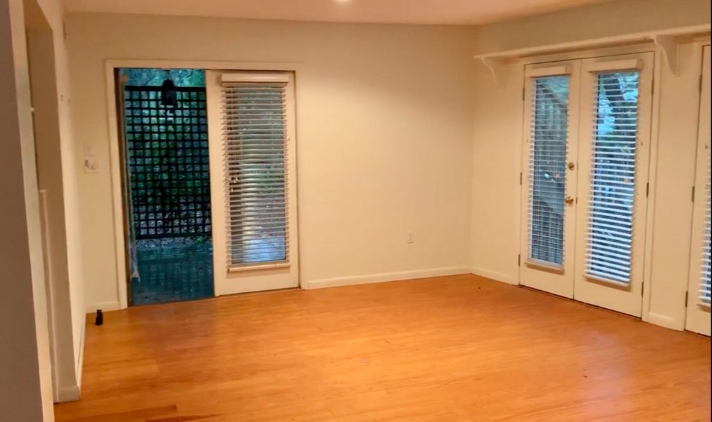 Before photo of living room turned bedroom with french doors on two walls