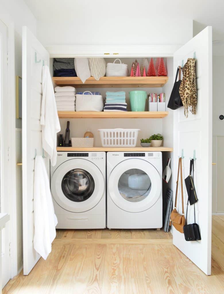 Wood laundry shelves installed in small laundry closet with lots of organization