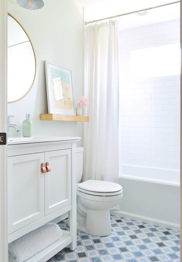 Duplex bathroom with white walls subway tile shower and blue patterned tile floor