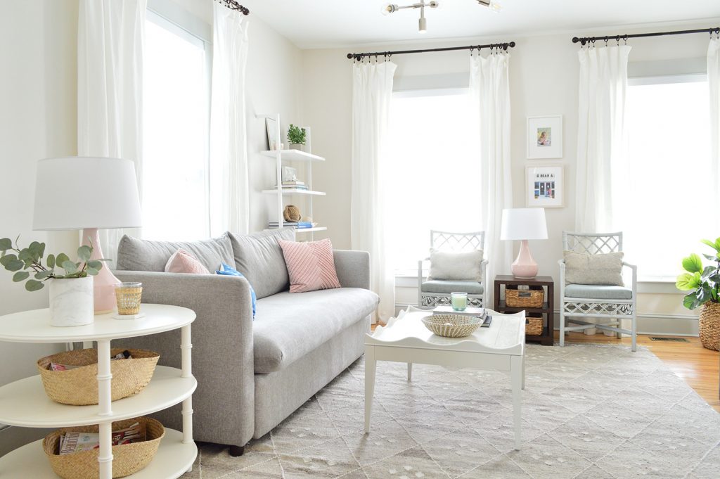 Beach house living room with tall white curtains on three windows