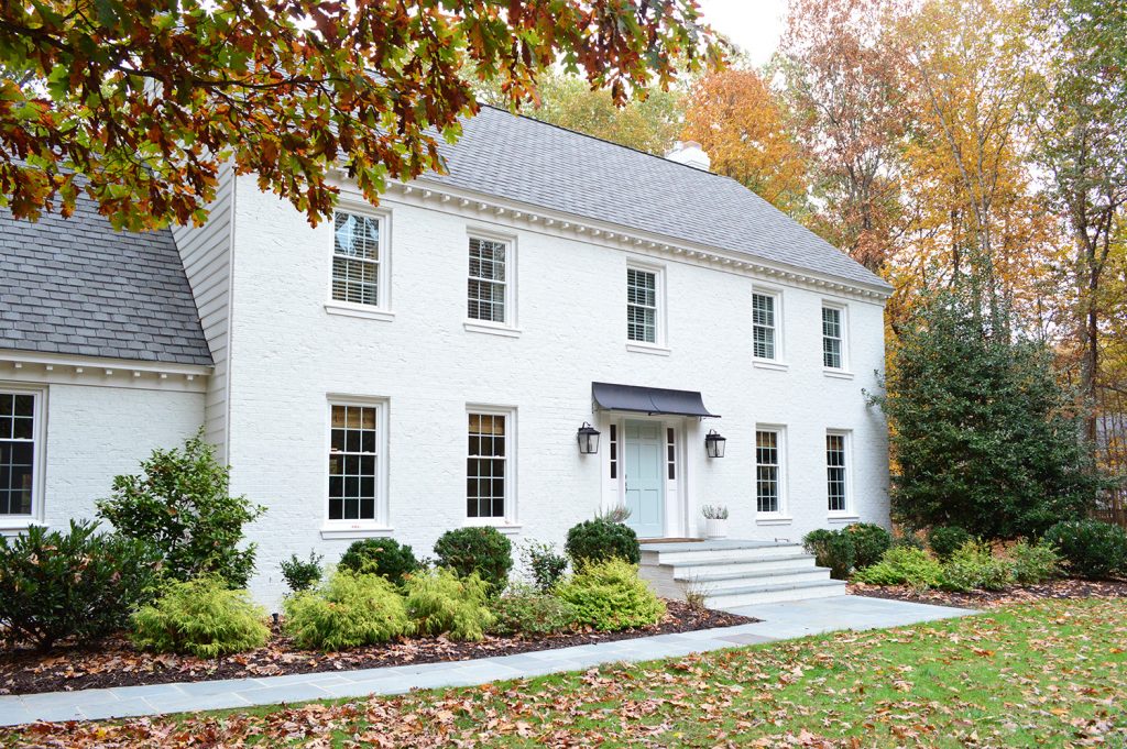 White Painted Brick House With Fall Leaves