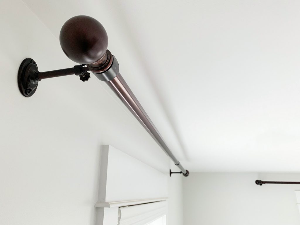 Allen + Roth Bronze curtain rods hung against white wall